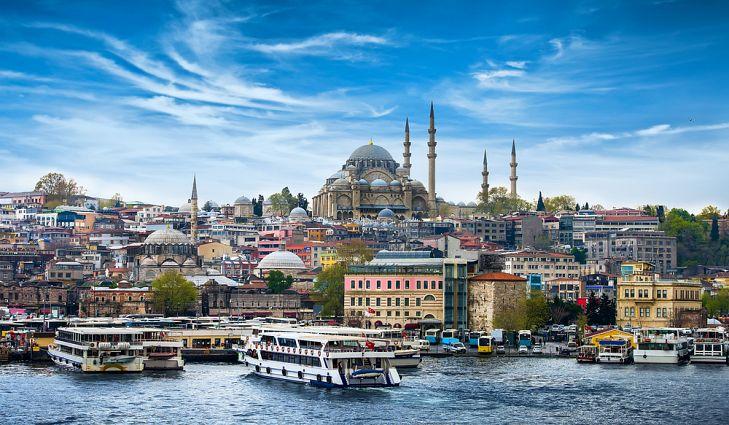 Picture of Turkish coastal city, with a mosque, colorful buildings, ships and cruise